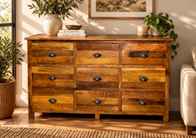 Load image into Gallery viewer, Commode 9 tiroirs en bois recyclé naturel aux planches de teintes variées, dans un salon