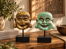 Charger l'image dans la galerie, Deux têtes de Bouddha rieur sur socles noirs, l'une dorée et l'autre vert-de-gris